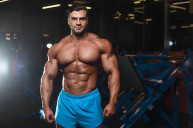 Yakışıklı genç uygun kas beyaz adam kilo kas, pozlar, pompalama spor modeli görünüm egzersiz eğitim su fitness ve vücut geliştirme spor beslenme kavramı içecekler