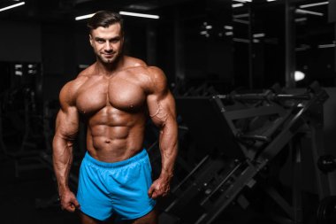 Yakışıklı genç uygun kas beyaz adam kilo kas, pozlar, pompalama spor modeli görünüm egzersiz eğitim su fitness ve vücut geliştirme spor beslenme kavramı içecekler