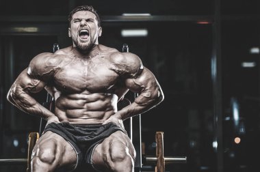 Yakışıklı genç kilo kas ve pozlar fitness ve vücut geliştirme spor beslenme kavramı pompalama jimnastik salonu kas beyaz adam modeli görünüm egzersiz eğitim yerleştirmek