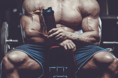 Vahşi seksi vücut geliştirme sporcusu kaslarını çalıştıran vücut geliştirme konsepti geliştiren sporcu. Spor salonunda çıplak vücut geliştirme egzersizleri yapan kaslı yakışıklı erkekler.