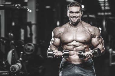 Kas beyaz yakışıklı genç model görünüm egzersiz eğitim silah içinde jimnastik salonu kas pazı ve tricep dumbbells fitness vücut geliştirme ve spor beslenme konsepti ile pompalama kilo