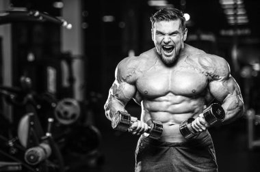 Kas beyaz yakışıklı genç model görünüm egzersiz eğitim silah içinde jimnastik salonu kas pazı ve tricep dumbbells fitness vücut geliştirme ve spor beslenme konsepti ile pompalama kilo