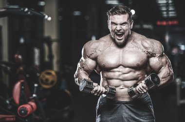 Kas beyaz yakışıklı genç model görünüm egzersiz eğitim silah içinde jimnastik salonu kas pazı ve tricep dumbbells fitness vücut geliştirme ve spor beslenme konsepti ile pompalama kilo