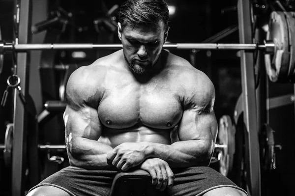 Vahşi seksi vücut geliştirme sporcusu kaslarını çalıştıran vücut geliştirme konsepti geliştiren sporcu. Spor salonunda çıplak vücut geliştirme egzersizleri yapan kaslı yakışıklı erkekler.