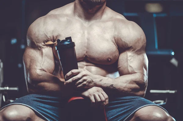 Vahşi seksi vücut geliştirme sporcusu kaslarını çalıştıran vücut geliştirme konsepti geliştiren sporcu. Spor salonunda çıplak vücut geliştirme egzersizleri yapan kaslı yakışıklı erkekler.