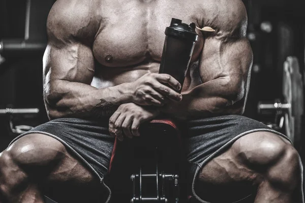 Vahşi seksi vücut geliştirme sporcusu kaslarını çalıştıran vücut geliştirme konsepti geliştiren sporcu. Spor salonunda çıplak vücut geliştirme egzersizleri yapan kaslı yakışıklı erkekler.