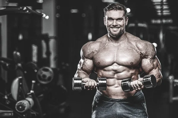 Kas beyaz yakışıklı genç model görünüm egzersiz eğitim silah içinde jimnastik salonu kas pazı ve tricep dumbbells fitness vücut geliştirme ve spor beslenme konsepti ile pompalama kilo
