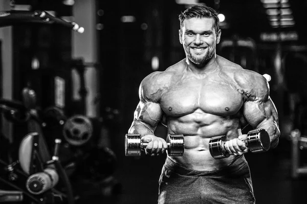 Kas beyaz yakışıklı genç model görünüm egzersiz eğitim silah içinde jimnastik salonu kas pazı ve tricep dumbbells fitness vücut geliştirme ve spor beslenme konsepti ile pompalama kilo