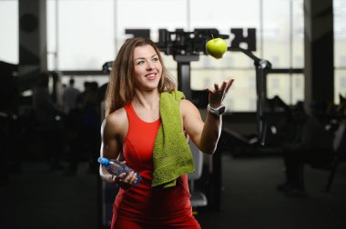 Güzel güçlü seksi atletik genç beyaz fitness kız su şişesi ve apple egzersiz spor eğitim abs kas pompalama ve vücut geliştirme sağlık ve fitness kavramı poz diyet