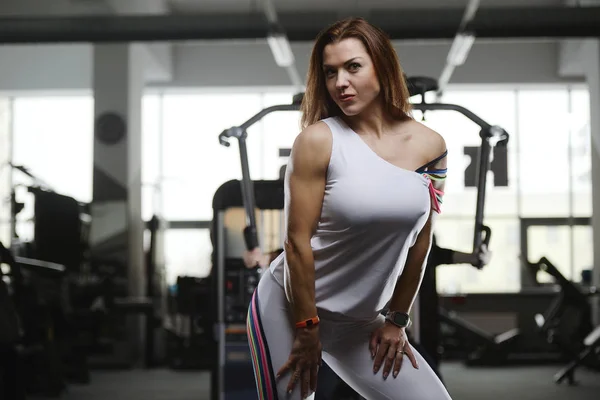 漂亮而性感的运动肌肉年轻的高加索女子健身训练在健身房里进行 训练内容是饮食 锻练腹肌和提出健美的保健和健身理念 — 图库照片