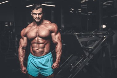 Yakışıklı genç uygun kas beyaz adam kilo kas, pozlar, pompalama spor modeli görünüm egzersiz eğitim su fitness ve vücut geliştirme spor beslenme kavramı içecekler