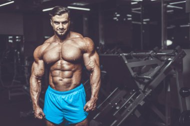 Yakışıklı genç uygun kas beyaz adam kilo kas, pozlar, pompalama spor modeli görünüm egzersiz eğitim su fitness ve vücut geliştirme spor beslenme kavramı içecekler