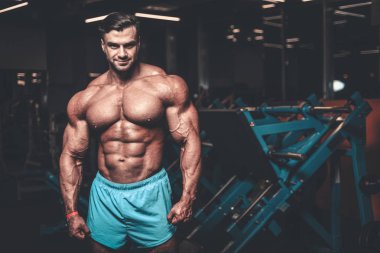 Yakışıklı genç uygun kas beyaz adam kilo kas, pozlar, pompalama spor modeli görünüm egzersiz eğitim su fitness ve vücut geliştirme spor beslenme kavramı içecekler