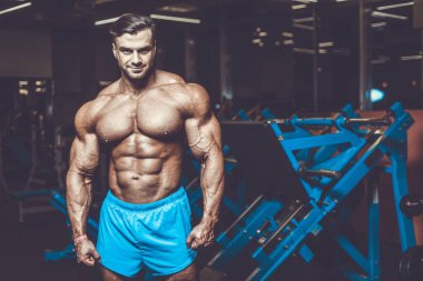 Yakışıklı genç uygun kas beyaz adam kilo kas, pozlar, pompalama spor modeli görünüm egzersiz eğitim su fitness ve vücut geliştirme spor beslenme kavramı içecekler