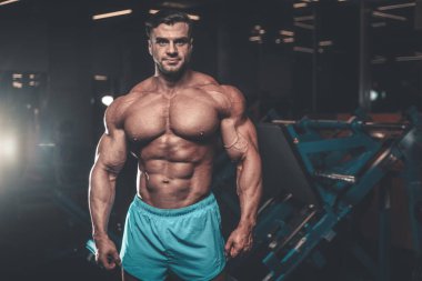Yakışıklı genç uygun kas beyaz adam kilo kas, pozlar, pompalama spor modeli görünüm egzersiz eğitim su fitness ve vücut geliştirme spor beslenme kavramı içecekler