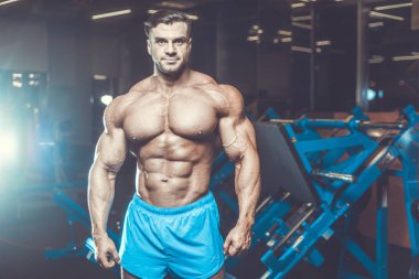 Yakışıklı genç uygun kas beyaz adam kilo kas, pozlar, pompalama spor modeli görünüm egzersiz eğitim su fitness ve vücut geliştirme spor beslenme kavramı içecekler