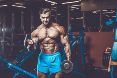 Yakışıklı genç uygun kas beyaz adam kilo kas, pozlar, pompalama spor modeli görünüm egzersiz eğitim su fitness ve vücut geliştirme spor beslenme kavramı içecekler