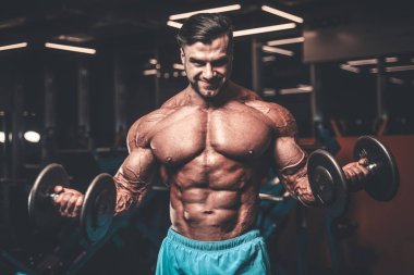 Yakışıklı genç uygun kas beyaz adam kilo kas, pozlar, pompalama spor modeli görünüm egzersiz eğitim su fitness ve vücut geliştirme spor beslenme kavramı içecekler