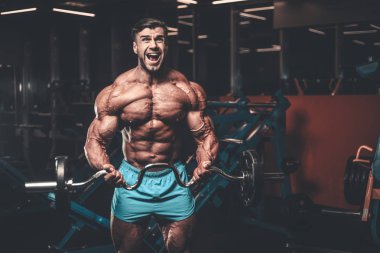 Yakışıklı genç uygun kas beyaz adam kilo kas, pozlar, pompalama spor modeli görünüm egzersiz eğitim su fitness ve vücut geliştirme spor beslenme kavramı içecekler