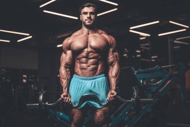 Yakışıklı genç uygun kas beyaz adam kilo kas, pozlar, pompalama spor modeli görünüm egzersiz eğitim su fitness ve vücut geliştirme spor beslenme kavramı içecekler