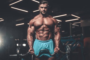 Yakışıklı genç uygun kas beyaz adam kilo kas, pozlar, pompalama spor modeli görünüm egzersiz eğitim su fitness ve vücut geliştirme spor beslenme kavramı içecekler