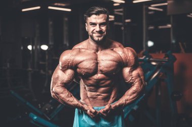 Yakışıklı genç uygun kas beyaz adam kilo kas, pozlar, pompalama spor modeli görünüm egzersiz eğitim su fitness ve vücut geliştirme spor beslenme kavramı içecekler