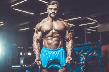 Yakışıklı genç uygun kas beyaz adam kilo kas, pozlar, pompalama spor modeli görünüm egzersiz eğitim su fitness ve vücut geliştirme spor beslenme kavramı içecekler