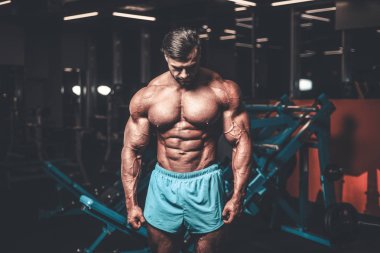 Yakışıklı genç uygun kas beyaz adam kilo kas, pozlar, pompalama spor modeli görünüm egzersiz eğitim su fitness ve vücut geliştirme spor beslenme kavramı içecekler