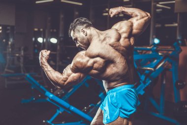 Yakışıklı genç uygun kas beyaz adam kilo kas, pozlar, pompalama spor modeli görünüm egzersiz eğitim su fitness ve vücut geliştirme spor beslenme kavramı içecekler