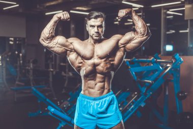 Yakışıklı genç uygun kas beyaz adam kilo kas, pozlar, pompalama spor modeli görünüm egzersiz eğitim su fitness ve vücut geliştirme spor beslenme kavramı içecekler