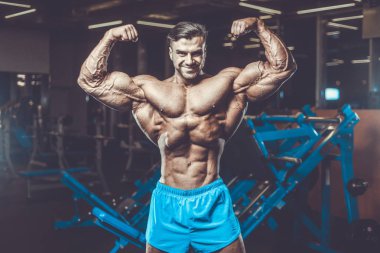 Yakışıklı genç uygun kas beyaz adam kilo kas, pozlar, pompalama spor modeli görünüm egzersiz eğitim su fitness ve vücut geliştirme spor beslenme kavramı içecekler