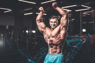 Yakışıklı genç uygun kas beyaz adam kilo kas, pozlar, pompalama spor modeli görünüm egzersiz eğitim su fitness ve vücut geliştirme spor beslenme kavramı içecekler