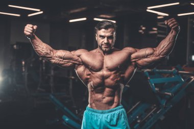 Yakışıklı genç uygun kas beyaz adam kilo kas, pozlar, pompalama spor modeli görünüm egzersiz eğitim su fitness ve vücut geliştirme spor beslenme kavramı içecekler