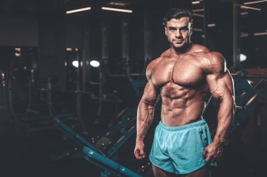 Yakışıklı genç uygun kas beyaz adam kilo kas, pozlar, pompalama spor modeli görünüm egzersiz eğitim su fitness ve vücut geliştirme spor beslenme kavramı içecekler
