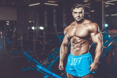 Yakışıklı genç uygun kas beyaz adam kilo kas, pozlar, pompalama spor modeli görünüm egzersiz eğitim su fitness ve vücut geliştirme spor beslenme kavramı içecekler