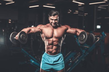 Yakışıklı genç uygun kas beyaz adam kilo kas, pozlar, pompalama spor modeli görünüm egzersiz eğitim su fitness ve vücut geliştirme spor beslenme kavramı içecekler