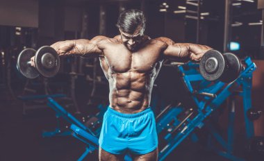 Yakışıklı genç uygun kas beyaz adam kilo kas, pozlar, pompalama spor modeli görünüm egzersiz eğitim su fitness ve vücut geliştirme spor beslenme kavramı içecekler