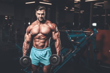 Yakışıklı genç uygun kas beyaz adam kilo kas, pozlar, pompalama spor modeli görünüm egzersiz eğitim su fitness ve vücut geliştirme spor beslenme kavramı içecekler