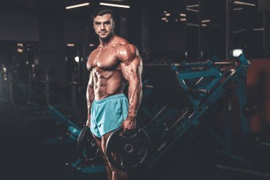 Yakışıklı genç uygun kas beyaz adam kilo kas, pozlar, pompalama spor modeli görünüm egzersiz eğitim su fitness ve vücut geliştirme spor beslenme kavramı içecekler