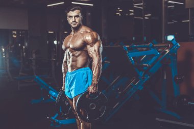 Yakışıklı genç uygun kas beyaz adam kilo kas, pozlar, pompalama spor modeli görünüm egzersiz eğitim su fitness ve vücut geliştirme spor beslenme kavramı içecekler