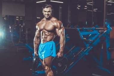 Yakışıklı genç uygun kas beyaz adam kilo kas, pozlar, pompalama spor modeli görünüm egzersiz eğitim su fitness ve vücut geliştirme spor beslenme kavramı içecekler