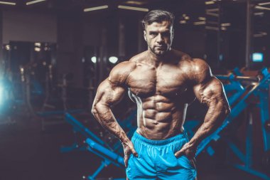 Yakışıklı genç uygun kas beyaz adam kilo kas, pozlar, pompalama spor modeli görünüm egzersiz eğitim su fitness ve vücut geliştirme spor beslenme kavramı içecekler