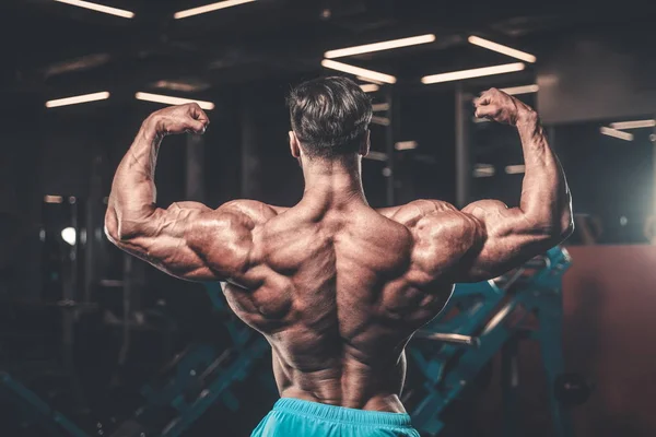 Yakışıklı genç uygun kas beyaz adam kilo kas, pozlar, pompalama spor modeli görünüm egzersiz eğitim su fitness ve vücut geliştirme spor beslenme kavramı içecekler