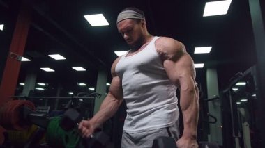 Güçlü atletik erkekler vücut geliştirme konusunda kas geliştiriyorlar. Kaslı vücut geliştirici yakışıklı erkekler spor salonunda çıplak gövde egzersizleri yapıyor.
