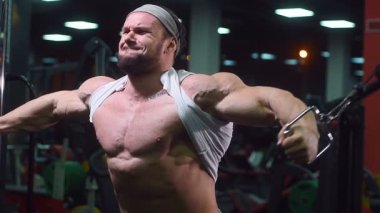 Güçlü atletik erkekler vücut geliştirme konusunda kas geliştiriyorlar. Kaslı vücut geliştirici yakışıklı erkekler spor salonunda çıplak gövde egzersizleri yapıyor.