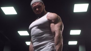 Güçlü atletik erkekler vücut geliştirme konusunda kas geliştiriyorlar. Kaslı vücut geliştirici yakışıklı erkekler spor salonunda çıplak gövde egzersizleri yapıyor.