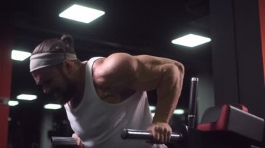 Güçlü atletik erkekler vücut geliştirme konusunda kas geliştiriyorlar. Kaslı vücut geliştirici yakışıklı erkekler spor salonunda çıplak gövde egzersizleri yapıyor.