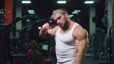 Güçlü atletik erkekler vücut geliştirme konusunda kas geliştiriyorlar. Kaslı vücut geliştirici yakışıklı erkekler spor salonunda çıplak gövde egzersizleri yapıyor.