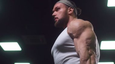 Güçlü atletik erkekler vücut geliştirme konusunda kas geliştiriyorlar. Kaslı vücut geliştirici yakışıklı erkekler spor salonunda çıplak gövde egzersizleri yapıyor.