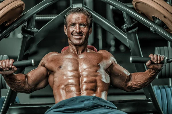 Acımasız güçlü vücut geliştirmeci atletik kasları egzersiz vücut geliştirme kavramı arka plan - kas vücut geliştirmeci yakışıklı erkekler spor salonu çıplak gövde kavramı spor ve diyet egzersiz yapıyor pompalama adam yaşlı